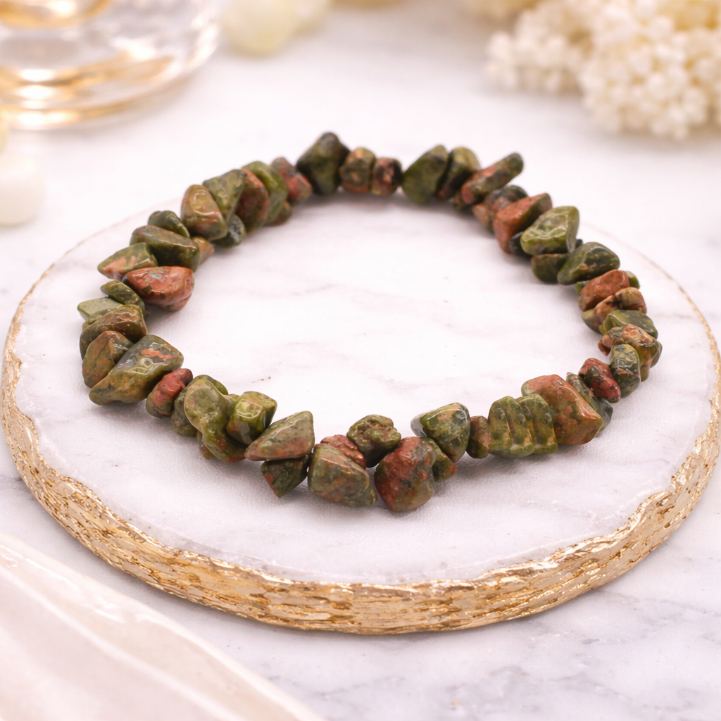 Elastisches grünes Jaspis Armband aus natürlichen Edelsteinen in grünen und erdigen Farbtönen, präsentiert auf hochwertiger Steinplatte