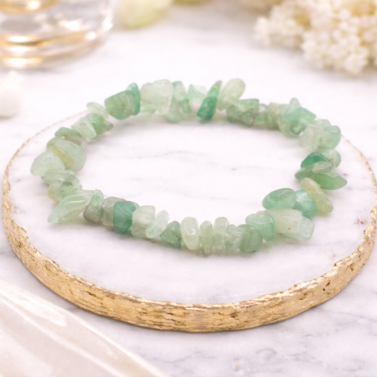 Elastisches Jade Armband aus natürlichen Edelsteinen in sanften grünen Nuancen, schlicht präsentiert auf hellem Hintergrund