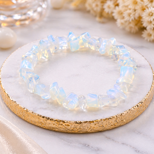 Opalit Chip Armband mit schimmernden milchig-blauen Steinen auf edler Steinplatte mit goldener Umrandung