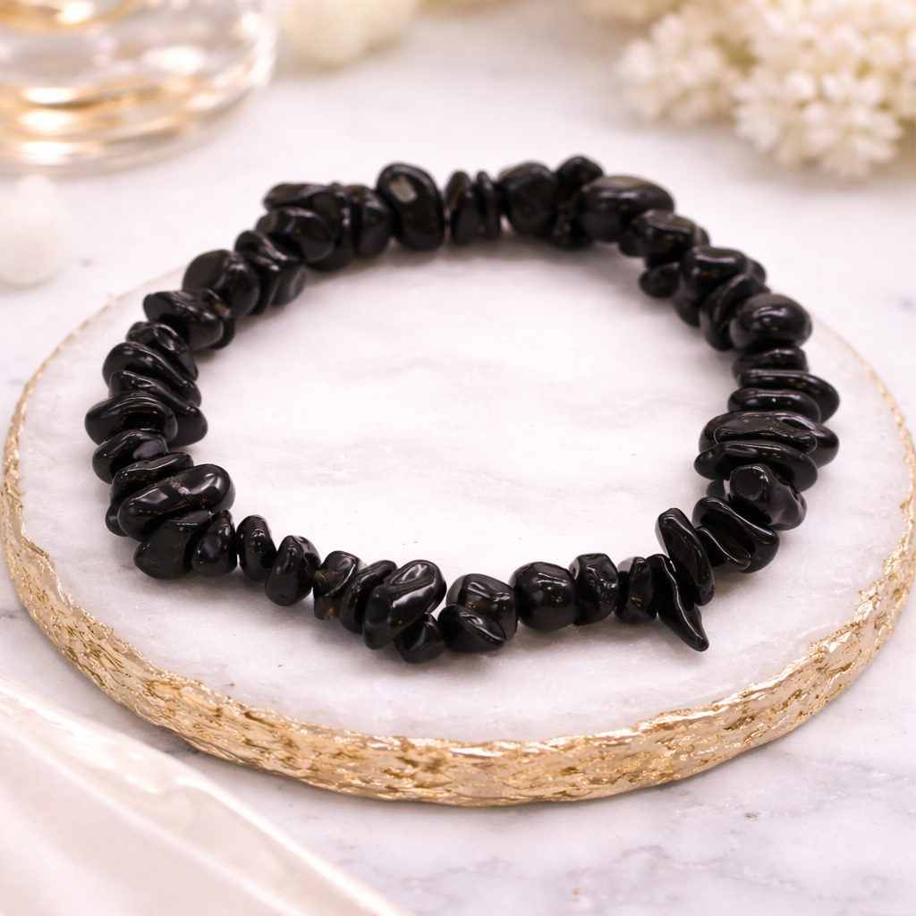 Schwarzes Achat Chip Armband aus Naturstein auf edler Steinplatte mit goldener Umrandung